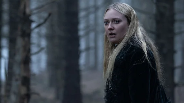 Dakota Fanning dans une forêt brumeuse, vêtue d'une tenue sombre, au regard préoccupé tourné vers la gauche.
