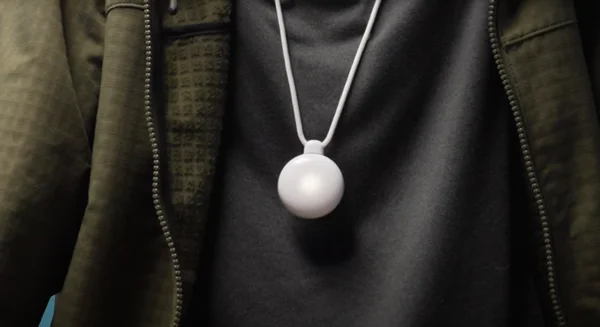 Un individu portant le pendentif IA Friend autour du cou.