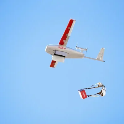 Un drone de livraison autonome Zipline posé dans un environnement résidentiel.