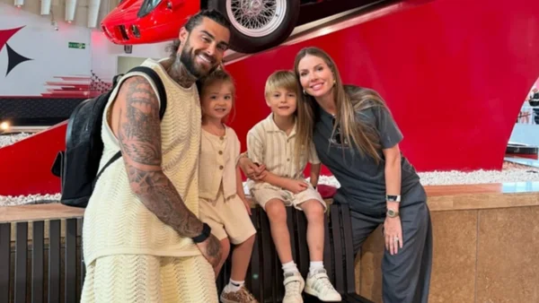 Jessica Thivenin, Thibault Garcia et leurs deux enfants posant en famille devant un décor ludique rouge.
