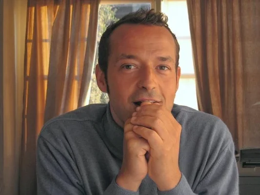 Stéphane Carlier, auteur de 'Clara lit Proust', photographed en intérieur devant une fenêtre donnant sur la nature.