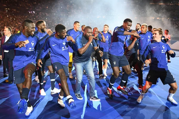 Les Bleus fêtant une victoire sur le terrain du Stade de France devant leurs supporters.