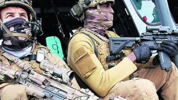 Deux soldats des Forces spéciales à l'intérieur d'un véhicule, prêts au combat.