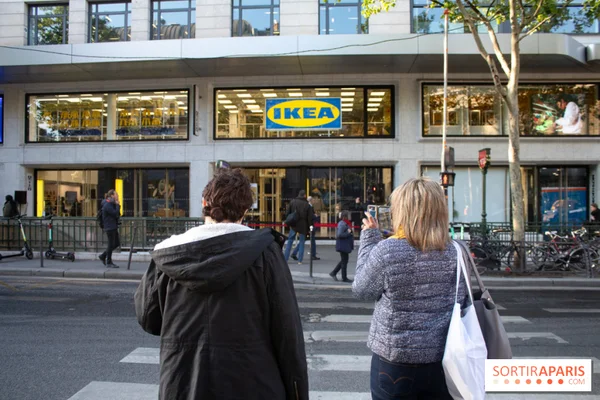 Deux personnes photographiant la devanture d'un magasin IKEA urbain.