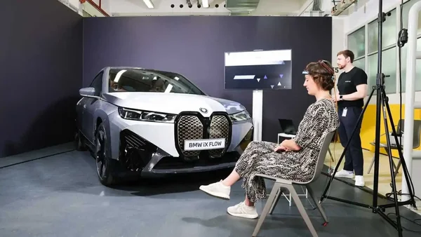 Le concept car BMW iX Flow, capable de changer de couleur, présenté dans un studio avec son équipe.
