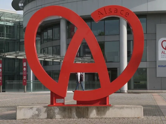 Sculpture emblématique « Alsace » devant un bâtiment moderne, symbolisant l'identité régionale.