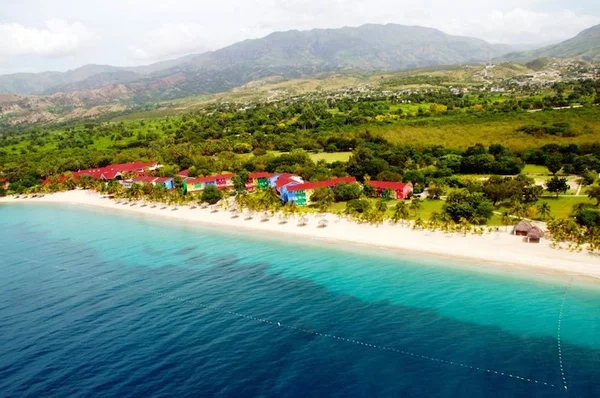 Vue aérienne de la station balnéaire tropicale de Labadee avec ses bâtiments colorés, sa plage de sable blanc et ses eaux turquoises.