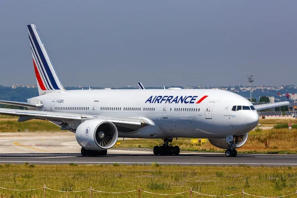 Un avion Air France blanc avec des rayons bleus et rouges sur la queue.