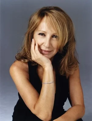 Nathalie Baye dans un portrait de studio own l'air pensive.