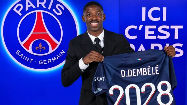 Ousmane Dembélé en costume noir présentant son maillot officiel du PSG numéroté 2028.