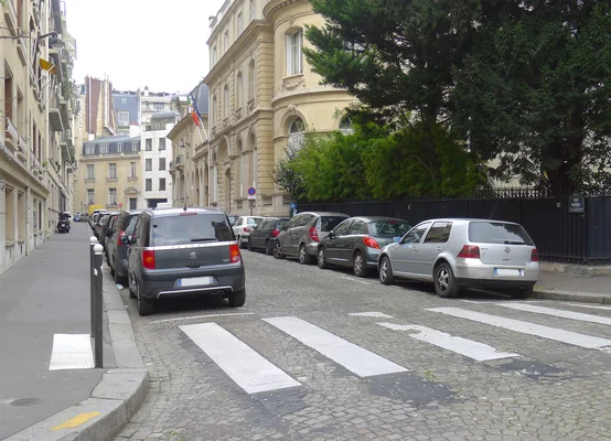 Une rue de Noisiel avec des immeubles en brique et un passage piéton.