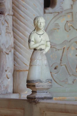 Statue d'une femme en marbre posée devant l'architecture décorative du Trône de marbre au palais du Golestan.