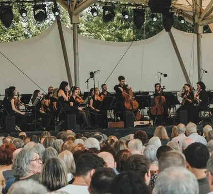 Musiciens d'un ensemble à cordes se produisant sous une tente blanche au festival Classique au Vert au Parc Floral.