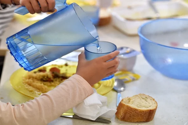 Service de l'eau et repas partiellement consommé sur un plateau.