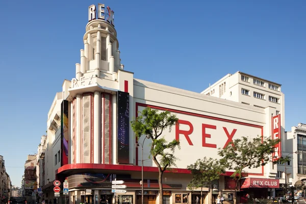 La façade blanche du Grand Rex avec ses lettres rouges caractéristiques, sous un ciel bleu dégagé.