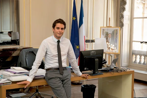 Gabriel Attal dans son bureau, devant les drapeaux de la France et de l'Union européenne.