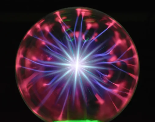 Réacteur plasma industriel émettant une lumière vive, montrant le traitement thermique de matériaux à l'intérieur d'une cage de sécurité.