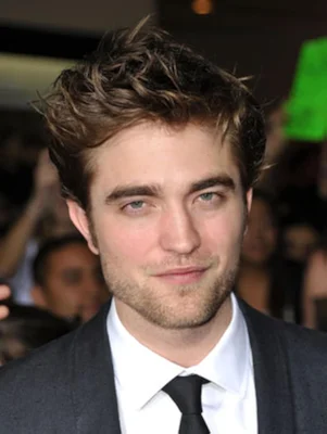 Portrait de Robert Pattinson en costume, les yeux fixés sur l'objectif.