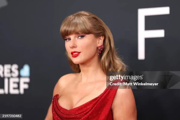Taylor Swift posant en robe rouge pour un portrait studio.