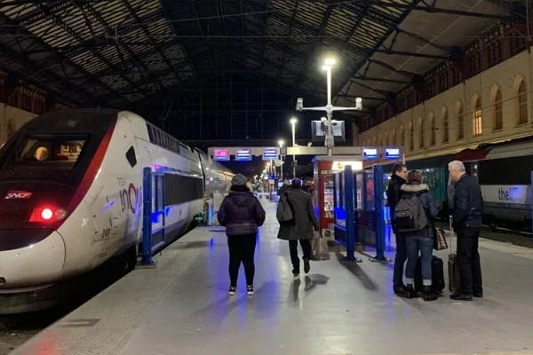 Passagers attendant sur un quai de gare à côté d'un TGV SNCF.