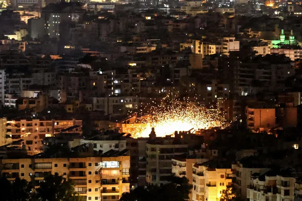 Une explosion spectaculaire dans la banlieue sud de Beyrouth lors d'une nuit de frappes israéliennes, avec des étincelles éclairant les immeubles environnants