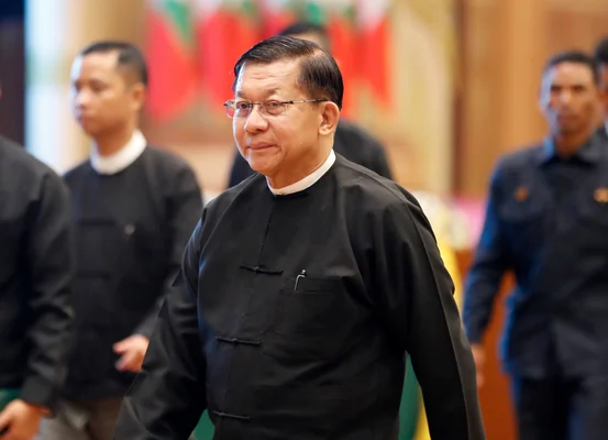 Min Aung Hlaing, en tenue civile traditionnelle, se déplace dans un cadre officiel.