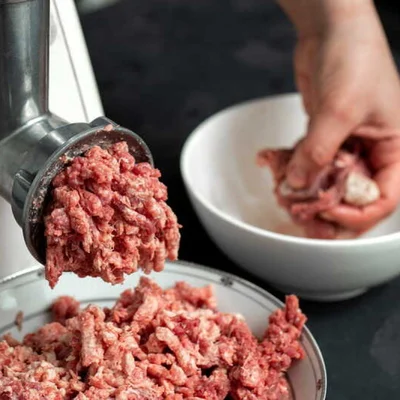 Viande hachée sortant d'un hachoir ménager.