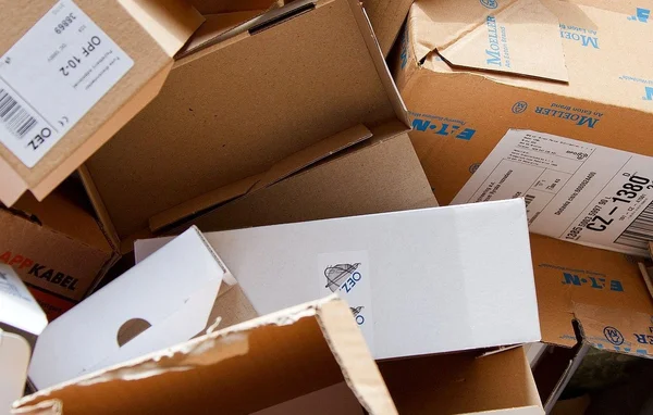 Un tas de cartons empilés affichant diverses étiquettes logistiques et marques de fabricants industriels.