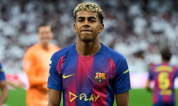 Lamine Yamal portant le maillot du FC Barcelone et faisant un geste OK à la caméra