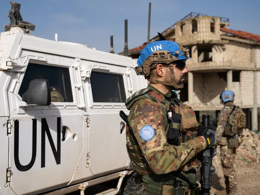 Un soldat de la paix de l'ONU surveille la zone près d'un véhicule blindé.