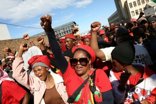 Des sympathisants de Julius Malema manifestant avec les poings levés.