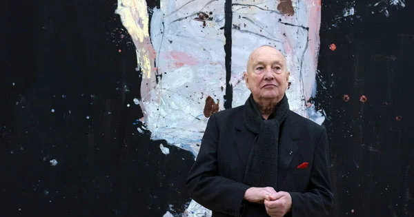 Portrait de l'artiste Georg Baselitz devant l'une de ses toiles.