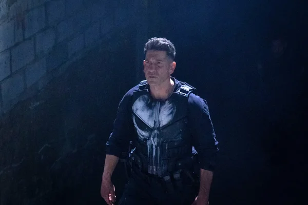 Un personnage en tenue tactique avec un crâne blanc sur la poitrine.