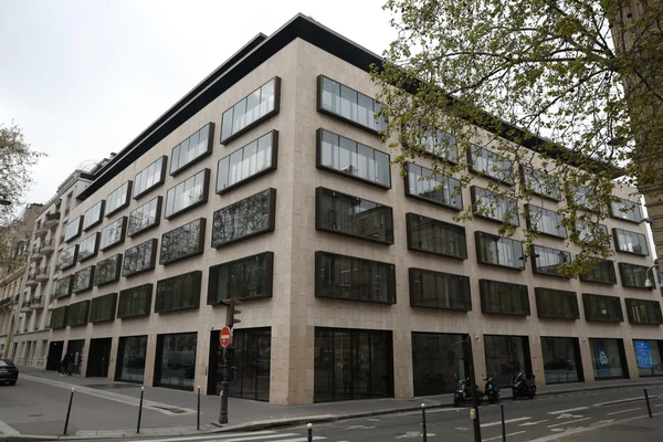 Immeuble moderne au coin d'une rue parisienne, correspondant au siège de Goldman Sachs visé par des menaces d'un groupe iranien.