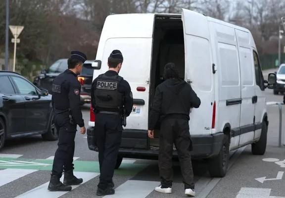 Des policiers examinant la fourgonnette impliquée dans la séquestration.