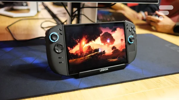 La Lenovo Legion Go posée sur un tapis de souris devant un fond de bureau en bois.