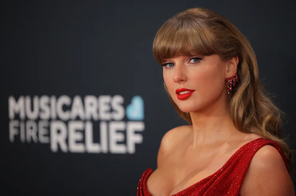 Taylor Swift lors d'un événement MusiCares Fire Relief, vêtue d'une robe rouge à paillettes.