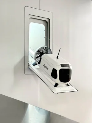 Un drone Zipline en vol avec sa nacelle de livraison suspendue sous le fuselage.