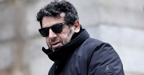 Patrick Bruel portant des lunettes de soleil noires.