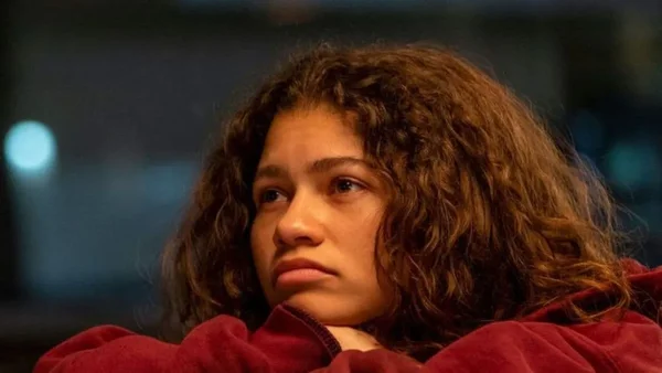 Gros plan de Zendaya, reconnaissable à sa chevelure bouclée, portant une tenue rouge.