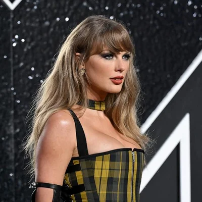 Taylor Swift arrivant aux MTV VMAs 2024 dans une tenue audacieuse à carreaux.