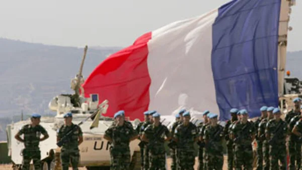 Soldats français de la Finul en formation devant le drapeau tricolore et un blindé onusien dans le Sud-Liban.