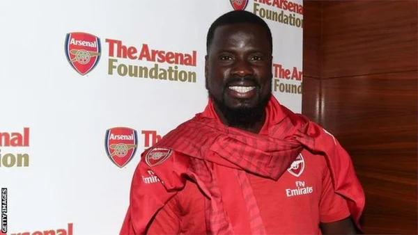 Emmanuel Eboué lors d'un événement pour The Arsenal Foundation, vêtu aux couleurs d'Arsenal.
