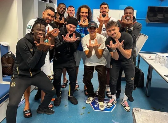 Jul célébrant une victoire de l'Olympique de Marseille avec le groupe dans le vestiaire.