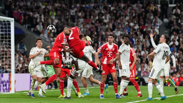 Joueurs du Real et du Bayern s'affrontant pour un ballon de tête près des buts.
