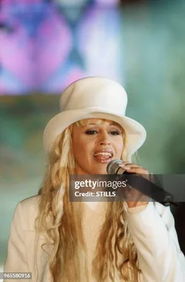 Lââm sur scène, vêtue de blanc et tenant un micro.