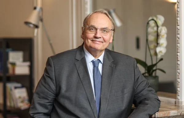 Jean-Louis Bourlanges assis dans un salon avec une bibliothèque en arrière-plan.