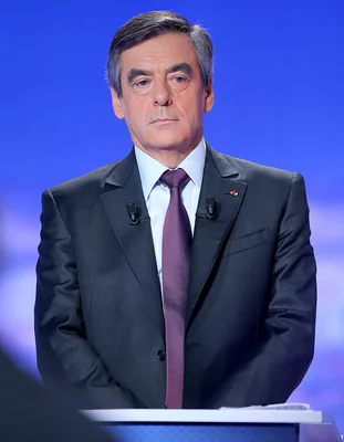 François Fillon posant devant un fond bleu.