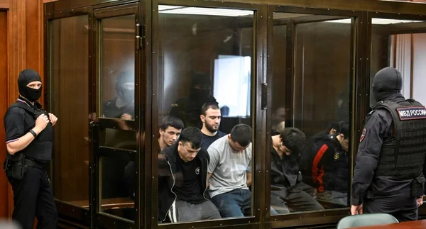 Les suspects de l'EI derrière le verre du box des accusés lors du procès à huis clos à Moscou.