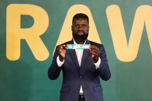 Emmanuel Eboué lors d'une apparition publique, vêtu d'un costume bleu marine.